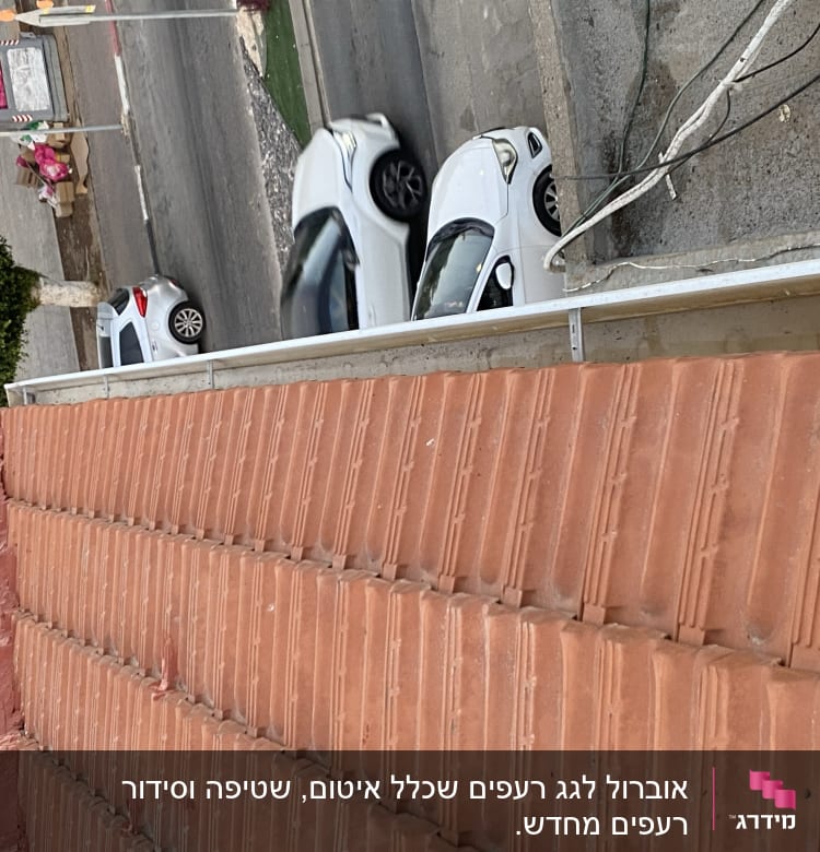 גג רעפים אדומים עם כבלים חשמליים בצד
